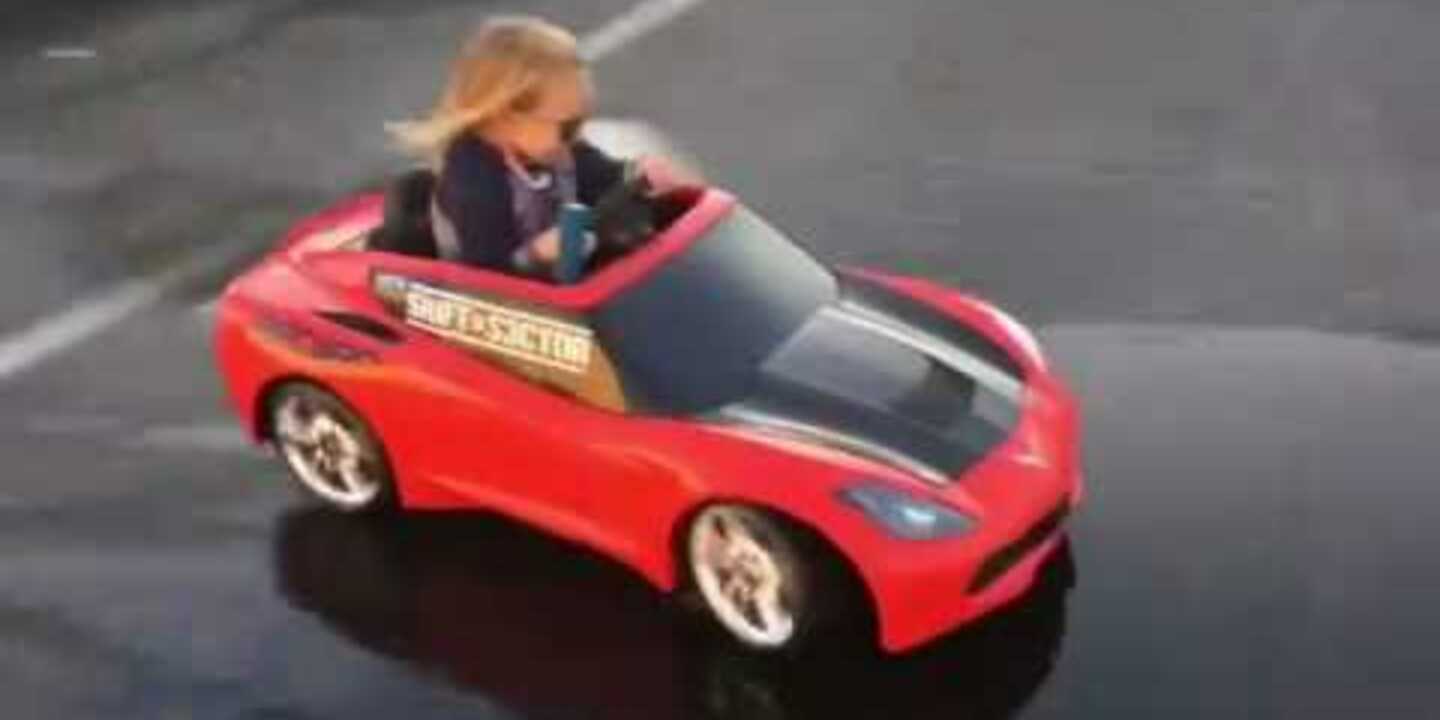 Une petite fille en glisse en mini voiture électrique