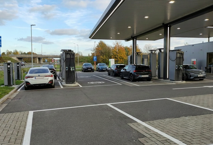 Des voitures électriques chargent le long d'une autoroute belge dans une station avec plusieurs bornes (hub)