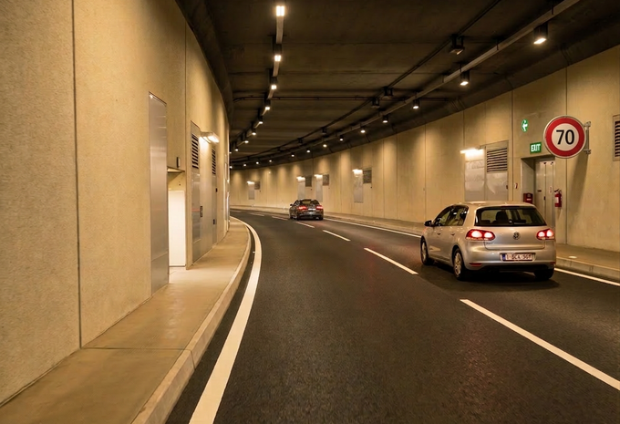 Intérieur d'un tunnel typiquement suisse avec une voiture belge et une signalisation de limitation de vitesse à 70 km/h