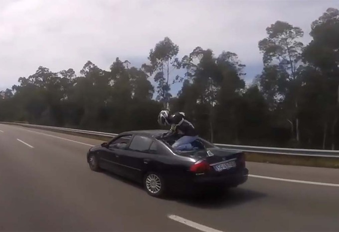 BIJZONDER: Motorrijder eindig op de kofferbak van een auto #1